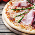 Pizza z szynką prosciutto - co wyróżnia włoską szynkę dojrzewającą?